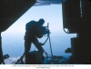 1375th aerial photographer shoots oblique photos from rear ramp of RC-130A aircraft.